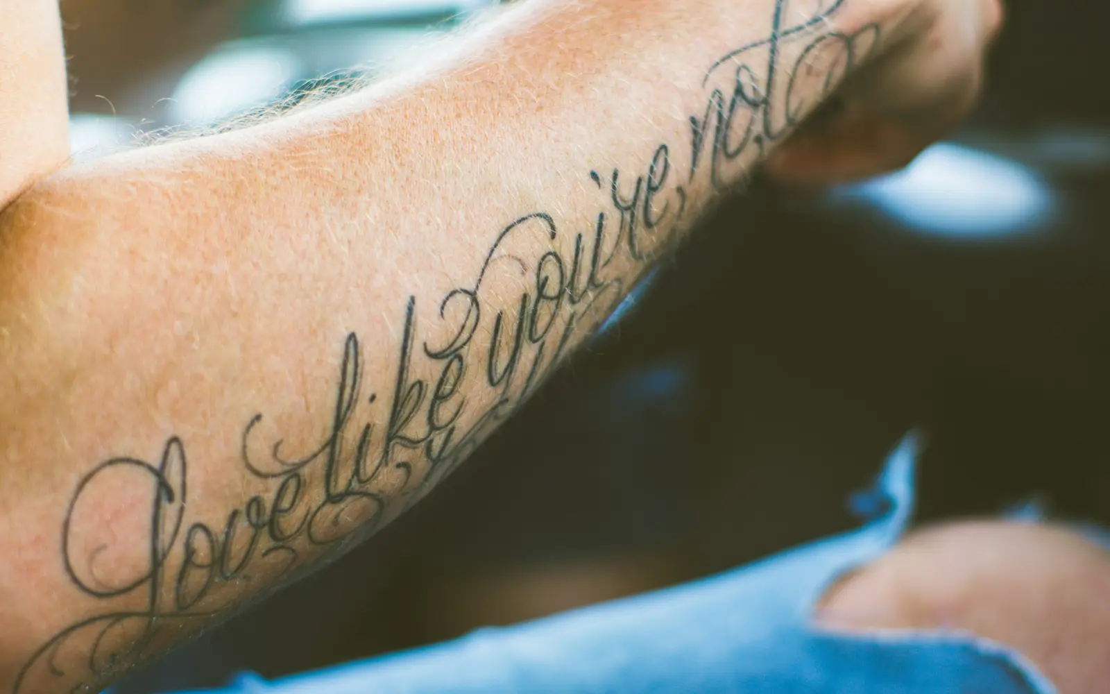 Script lettering tattoo on forearm