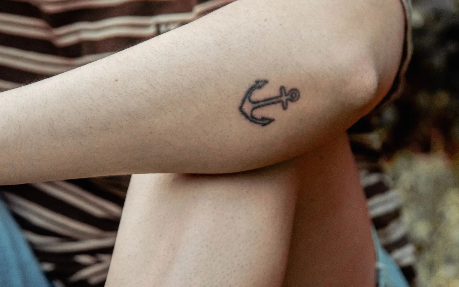 Small anchor tattoo on forearm outdoors