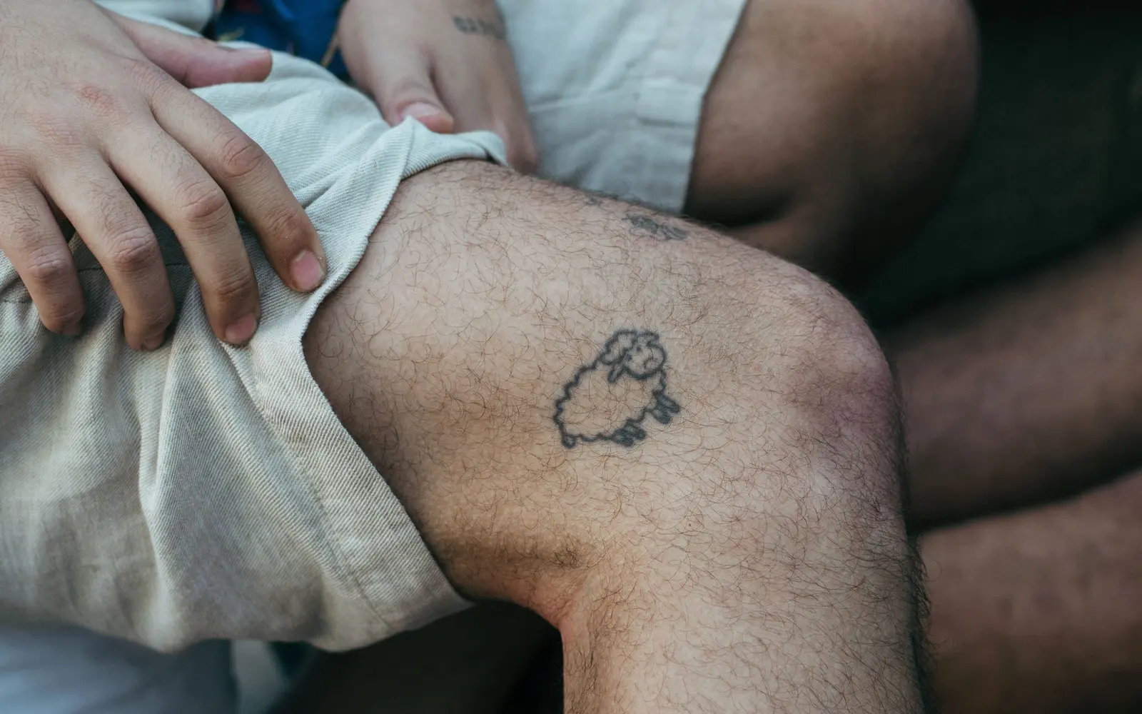 Minimalist sheep line-art tattoo on leg