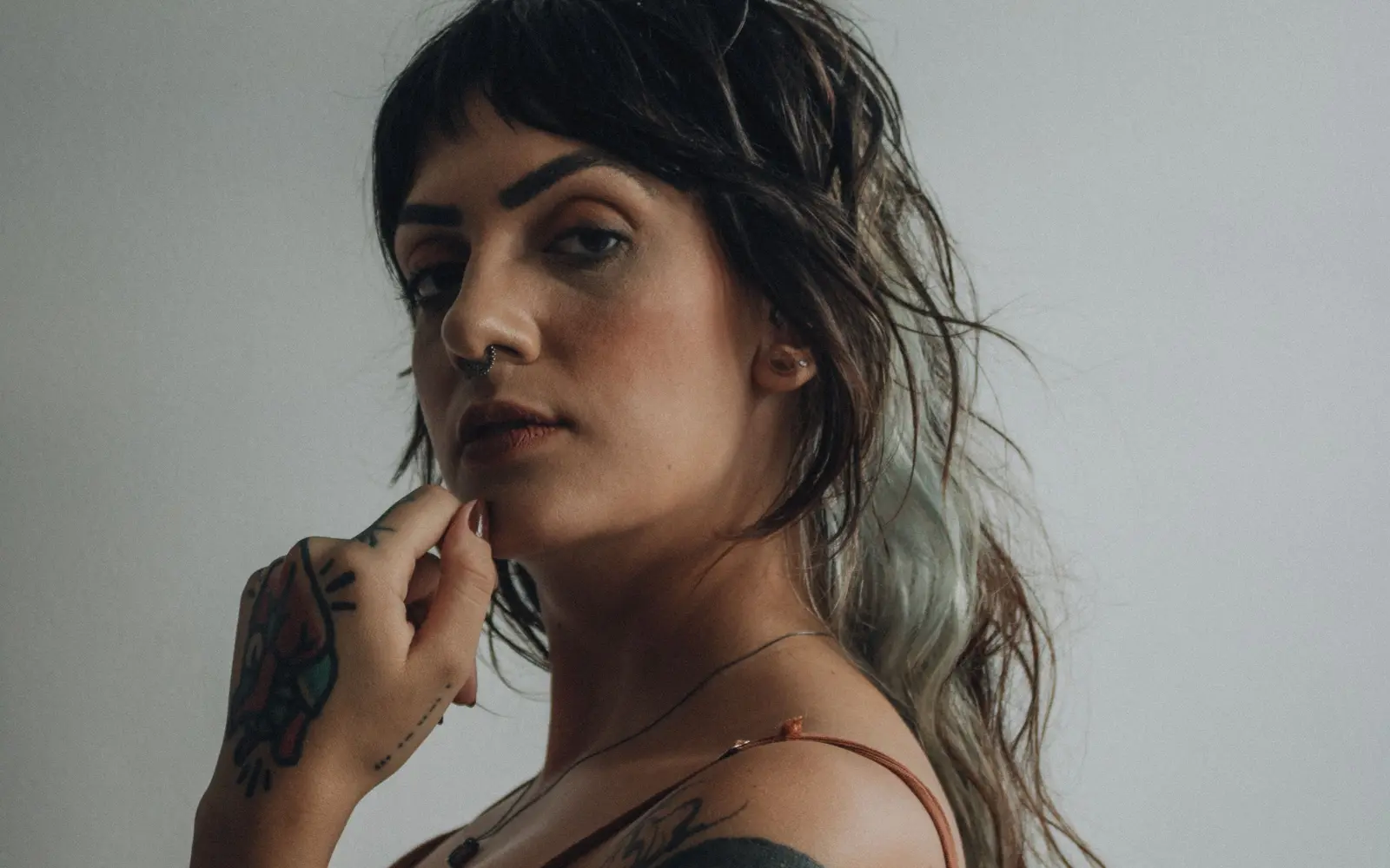 Tattooed woman in thoughtful pose showing body art